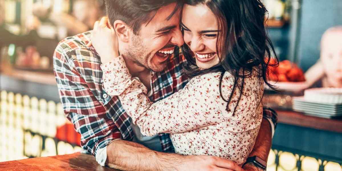 A Gemini woman and man laughing together, capturing the wit and mental connection she values most in a romantic partner