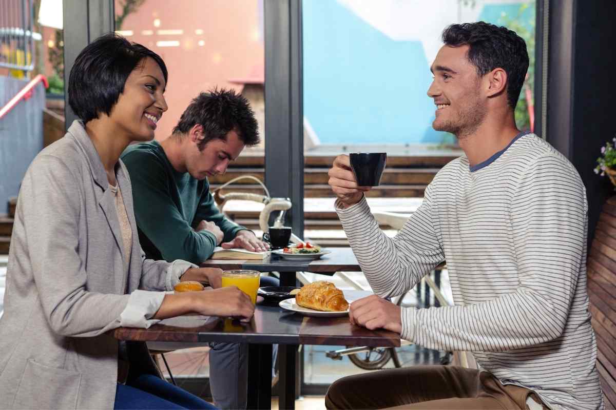 A man and woman engaged in thoughtful conversation over coffee