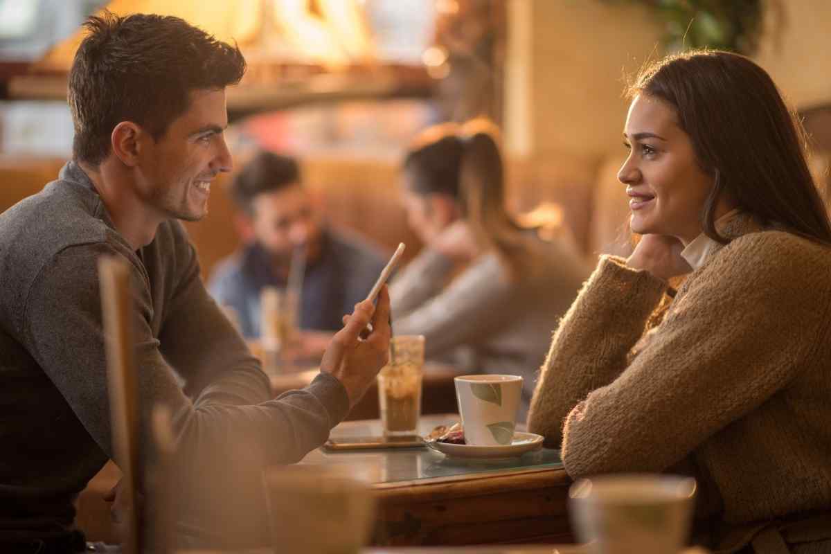 Two people sitting across from each other at a cafe, having a calm conversation