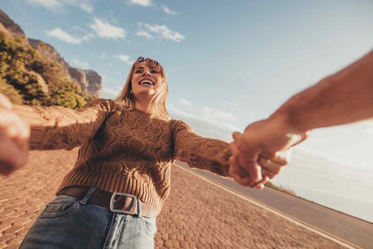An Aries woman standing with composed independence, her attention turned fully toward her own direction