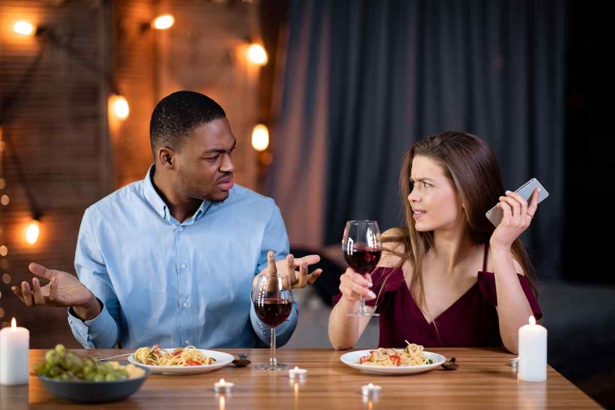 A couple at a table sitting in silence, each absorbed in their own thoughts