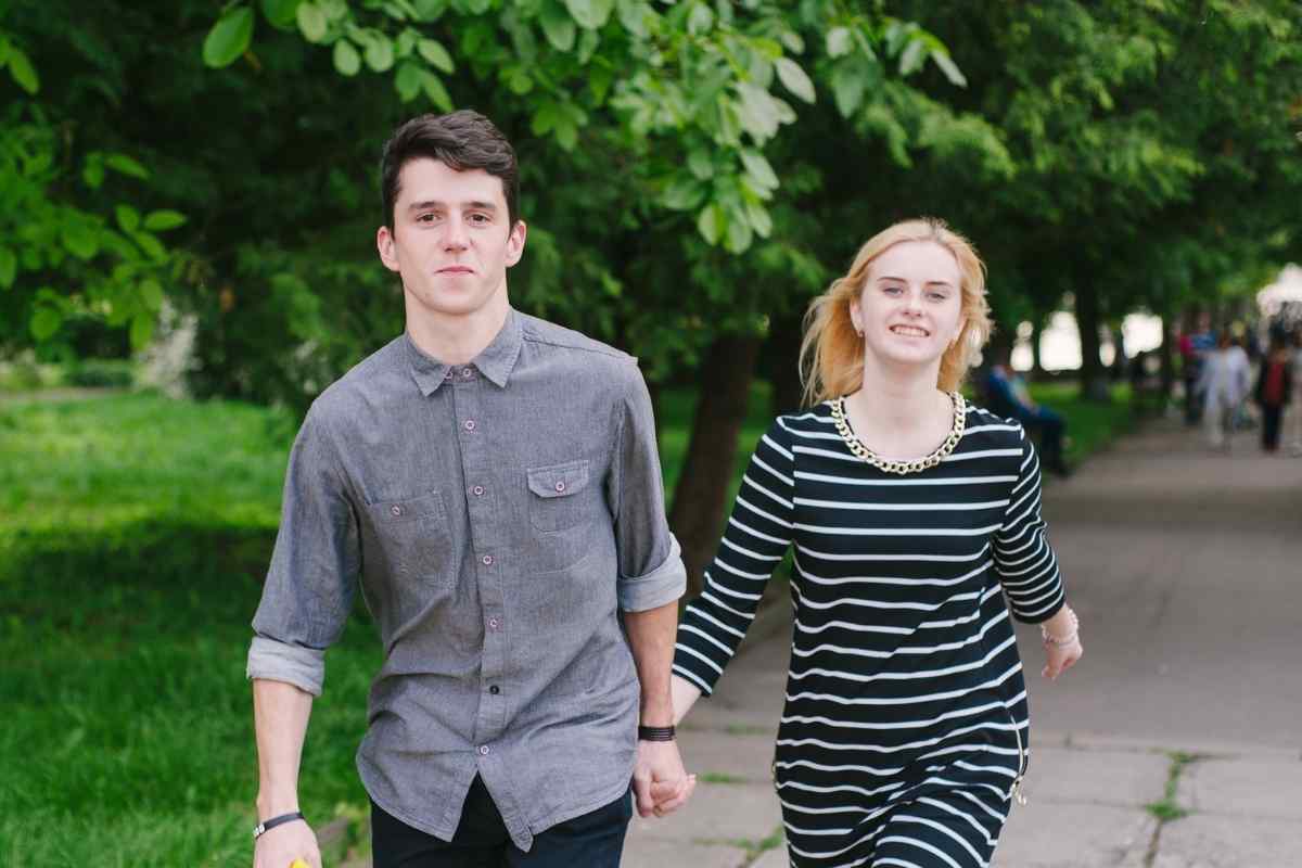 Two people sitting thoughtfully apart from each other, each looking ahead with calm composure in a quiet outdoor setting