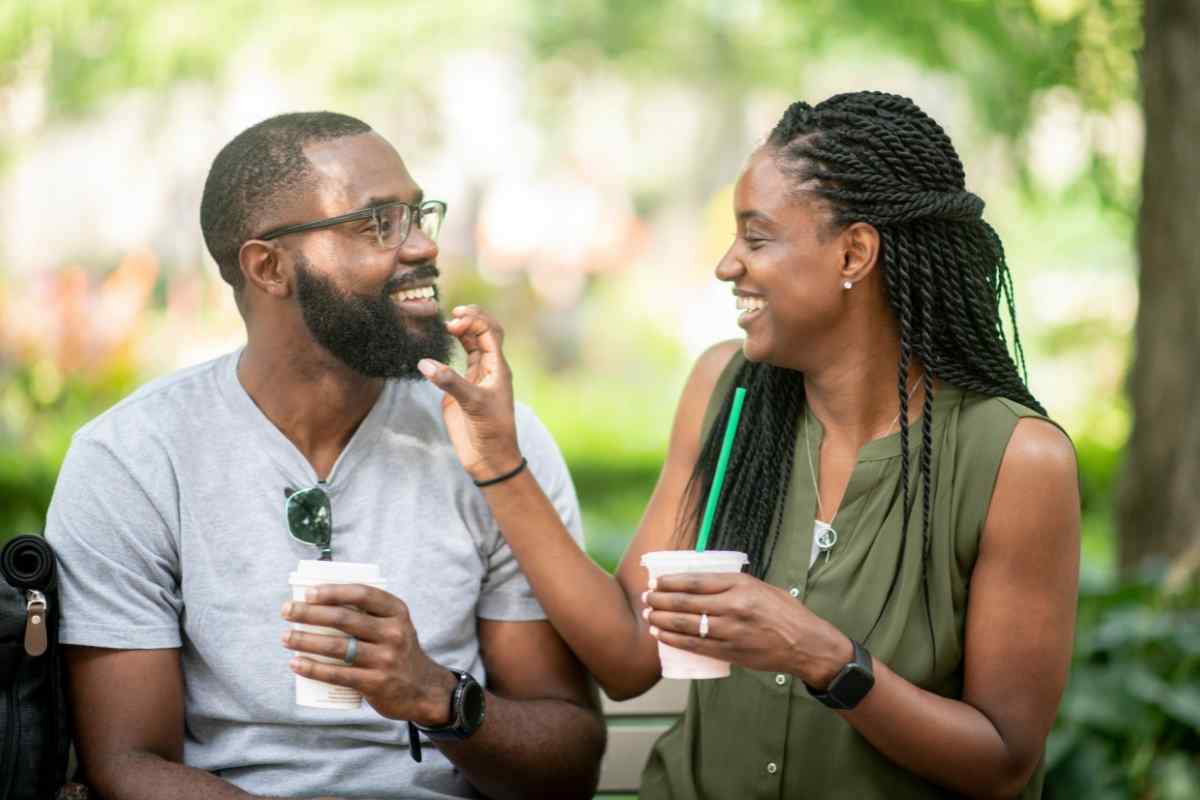 A man and woman sitting across from each other, engaged in a relaxed but focused conversation over coffee