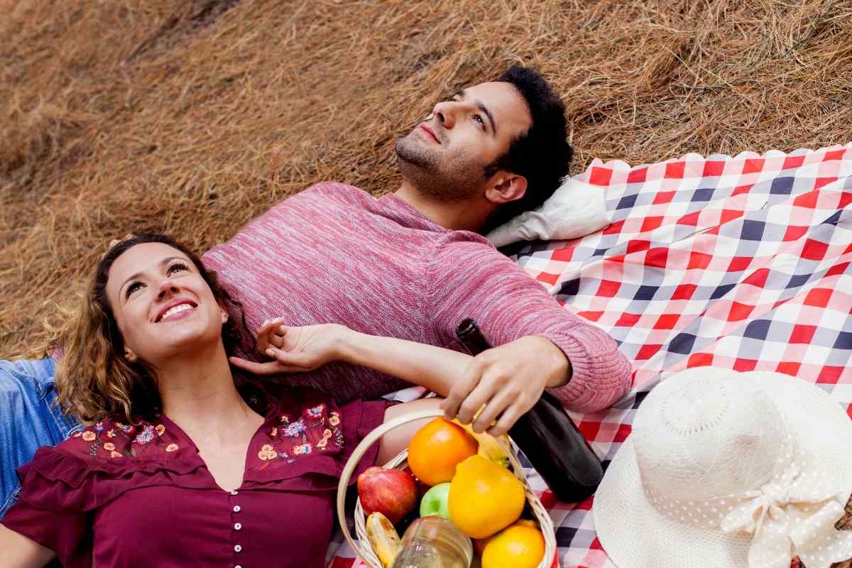 A couple sitting together looking at a shared plan on a laptop, representing the goal-oriented connection a Capricorn man values in a relationship