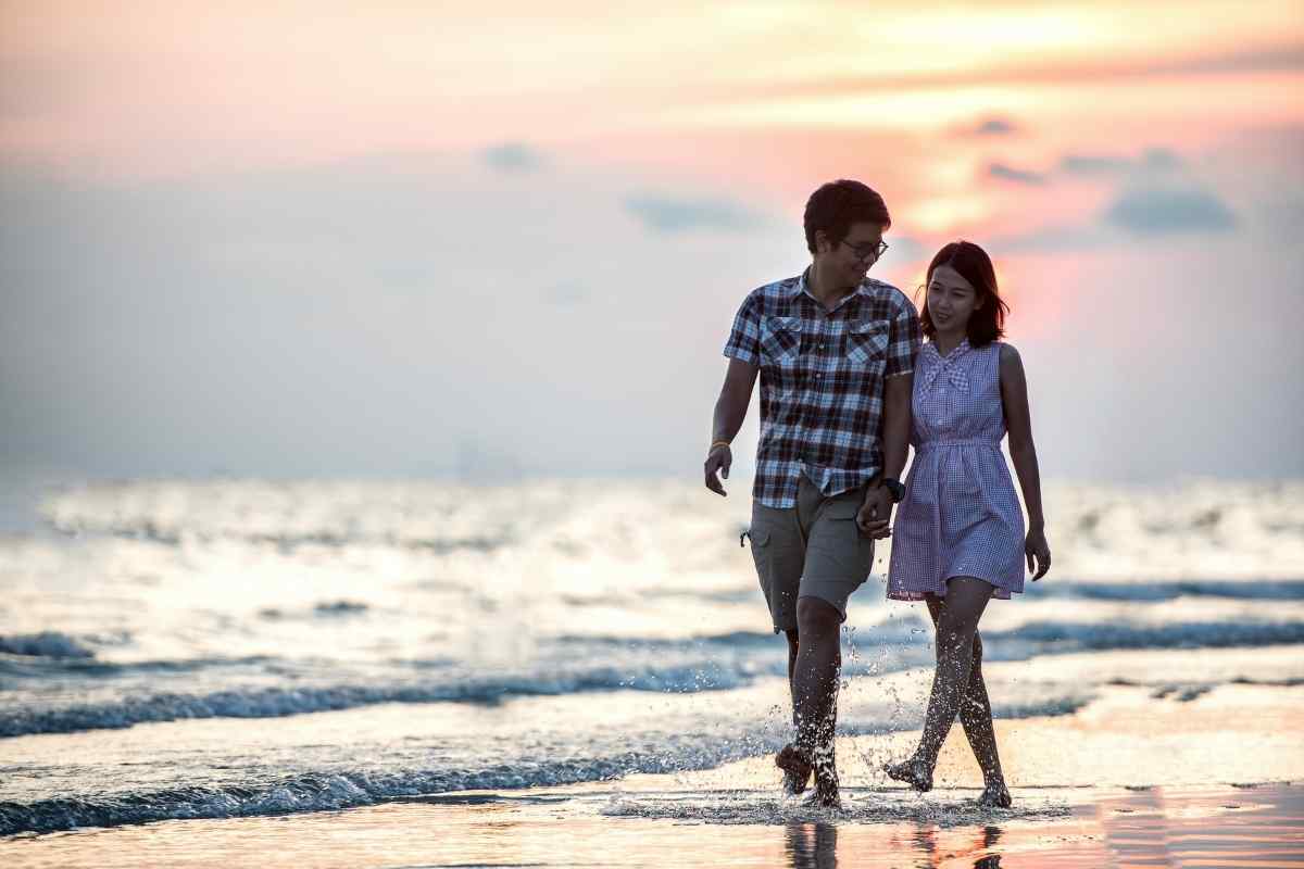 Sagittarius man and Aries woman sharing easy conversation outdoors, representing a fire sign pairing that manages long distance through shared independence