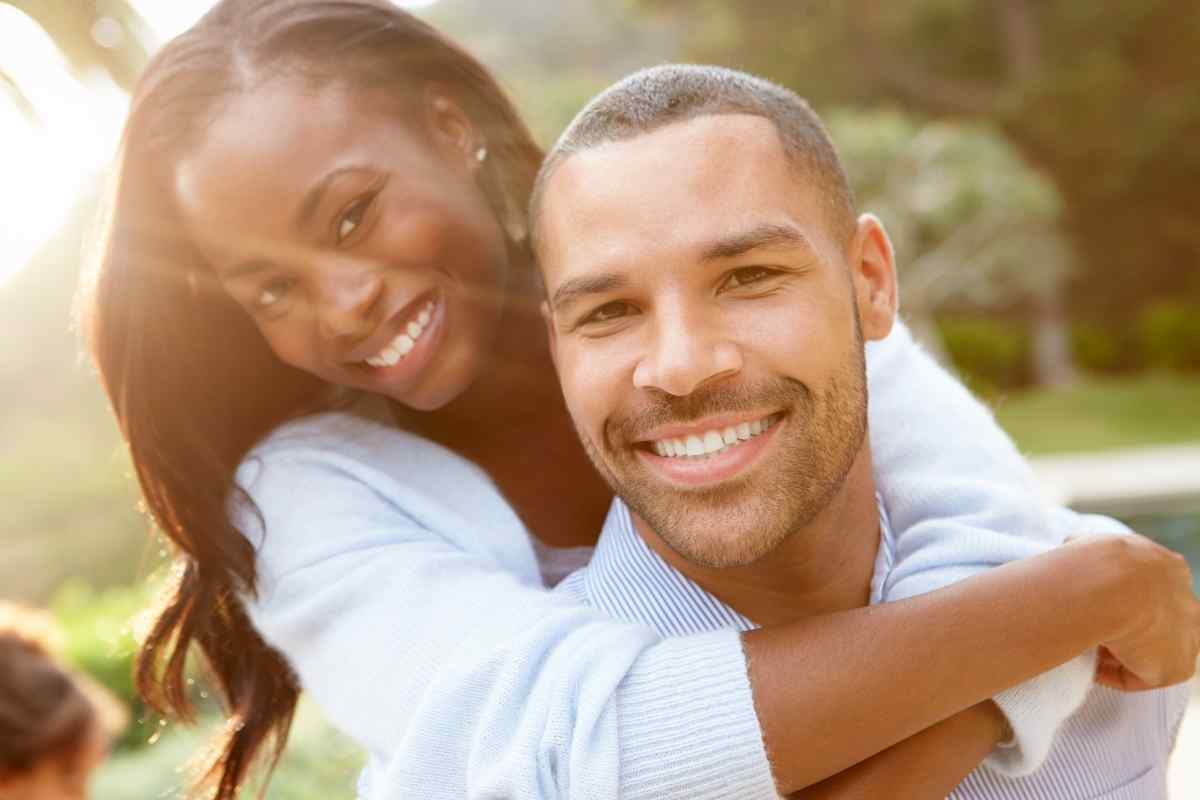 Couple lying together, woman gently resting her hand on her partner's stomach in a relaxed, trusting moment