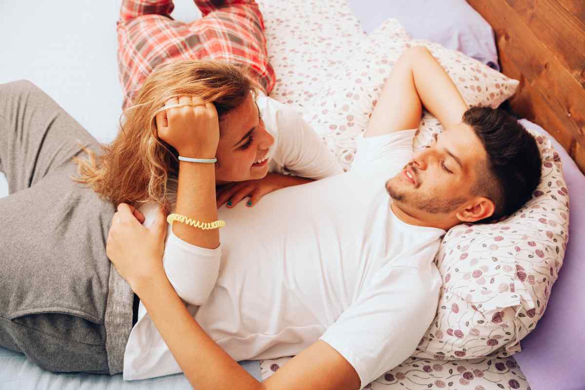 Couple in a quiet room, man gently pressing his fingers to his partner's temples in a soothing gesture