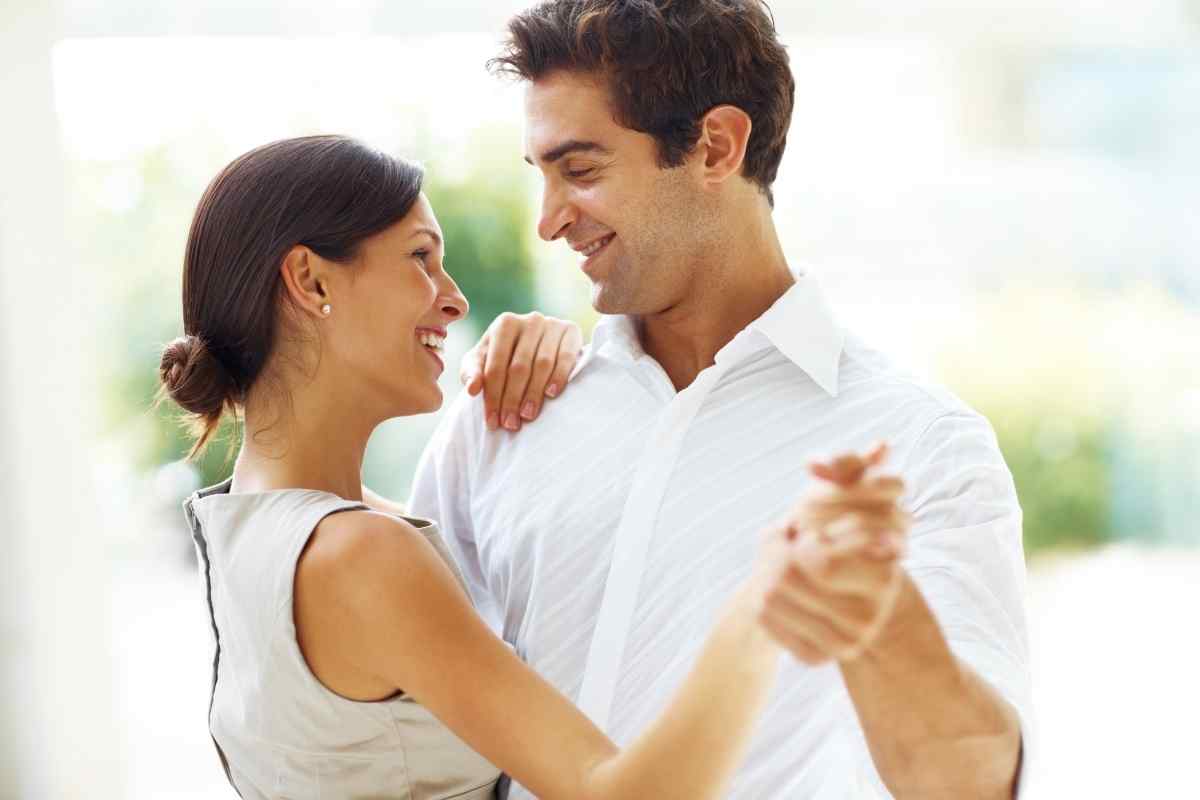 Woman seated beside her partner, hands gently wrapped around his lower leg in a calm, attentive moment