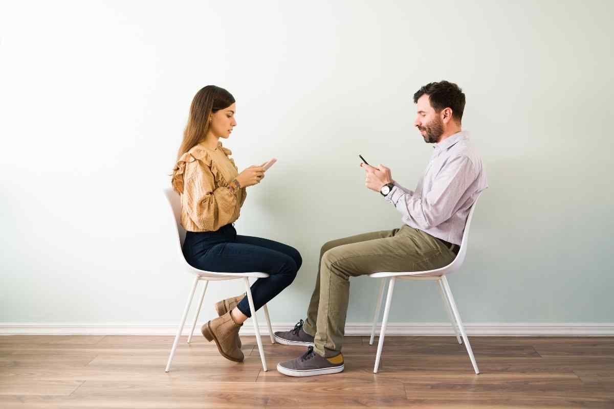 A man looking away during a conversation with his partner, his posture closed and evasive