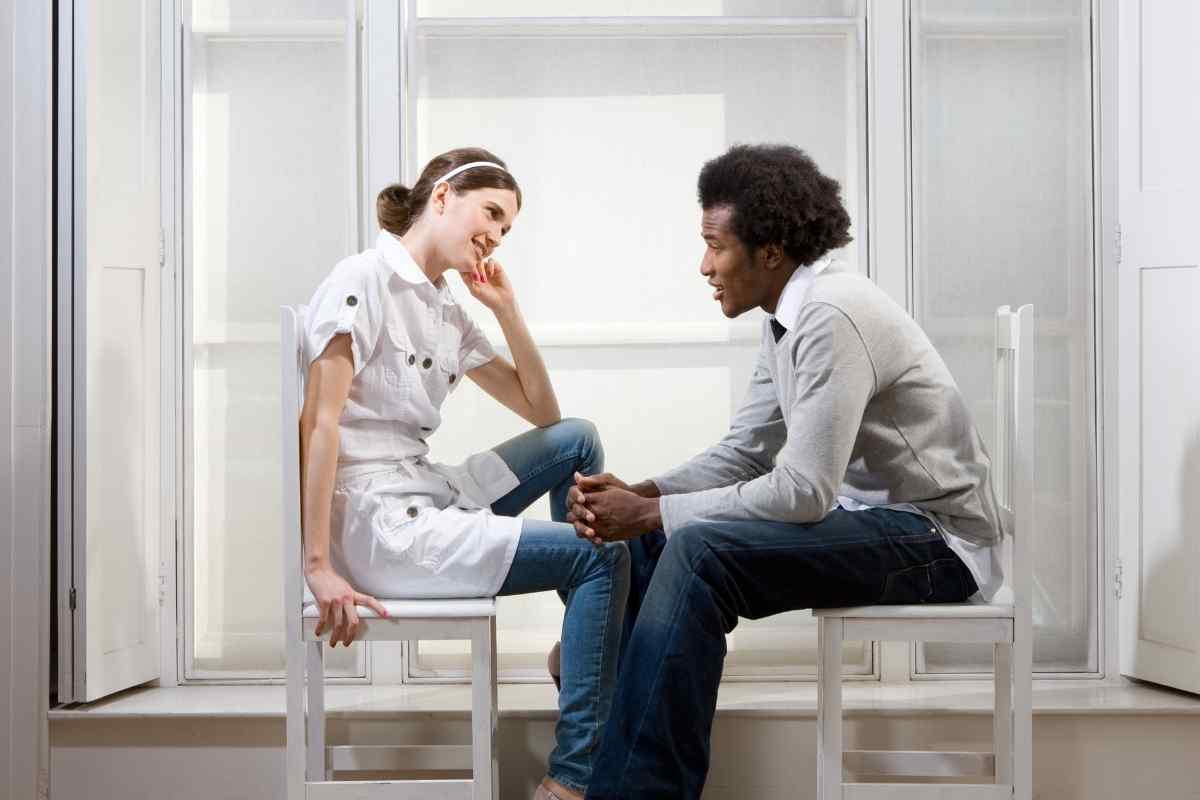 A woman sitting turned away from her partner, her attention elsewhere and her expression distant