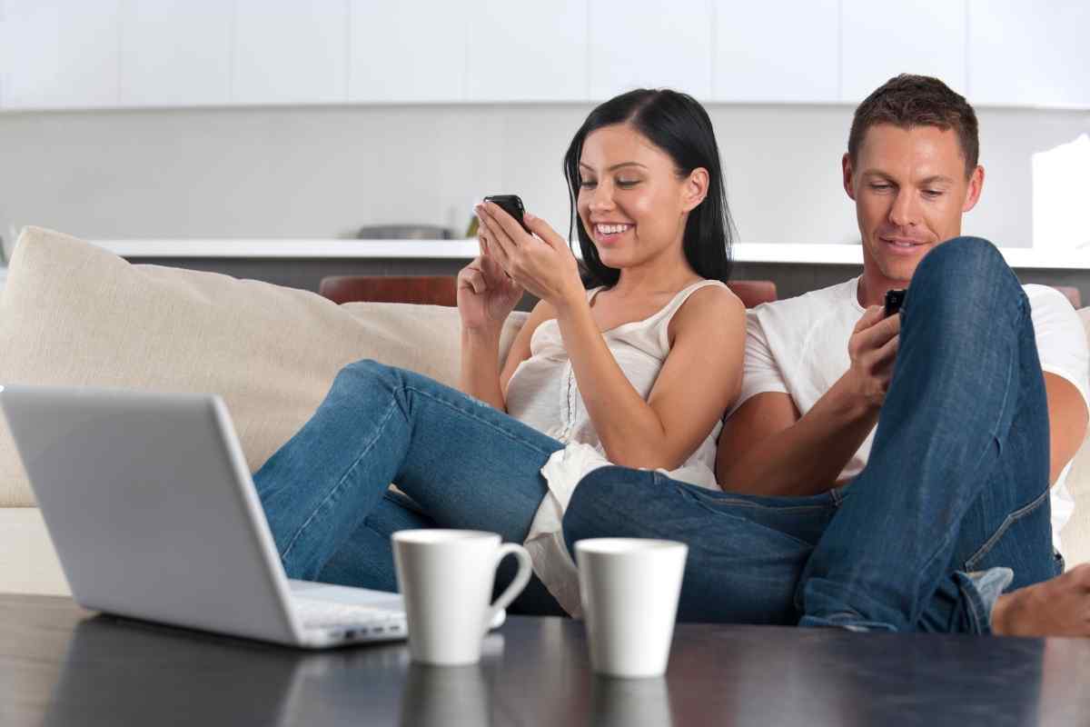 Two people laughing together over morning messages on their phones