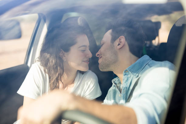 A couple sharing a soft, emotionally connected kiss in warm low light