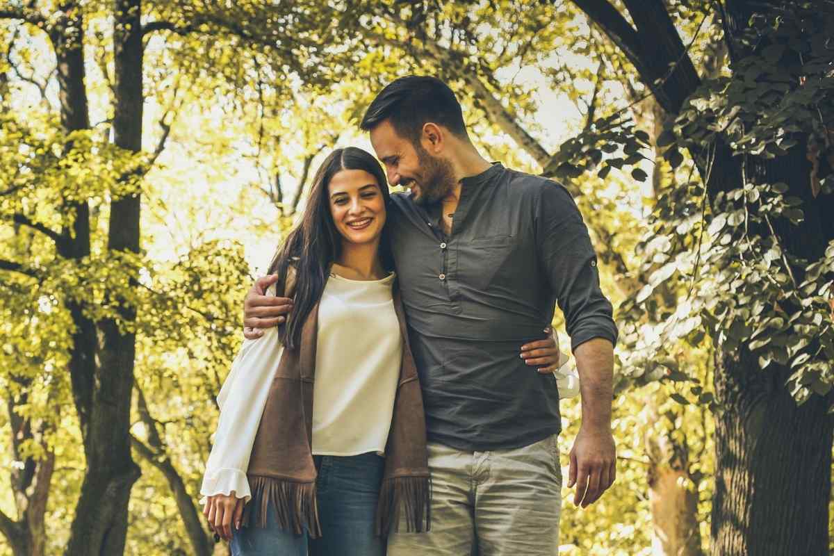 A couple sharing a spontaneous, full kiss outdoors in warm light