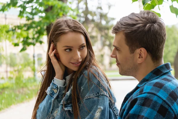 A woman warmly attentive to the man beside her, both relaxed and close