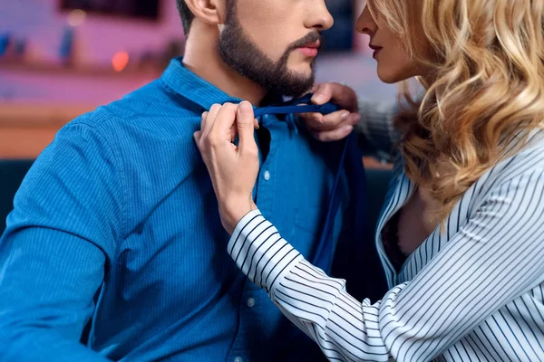 Woman handing a man a useful resource with a warm, focused expression in a calm and professional setting